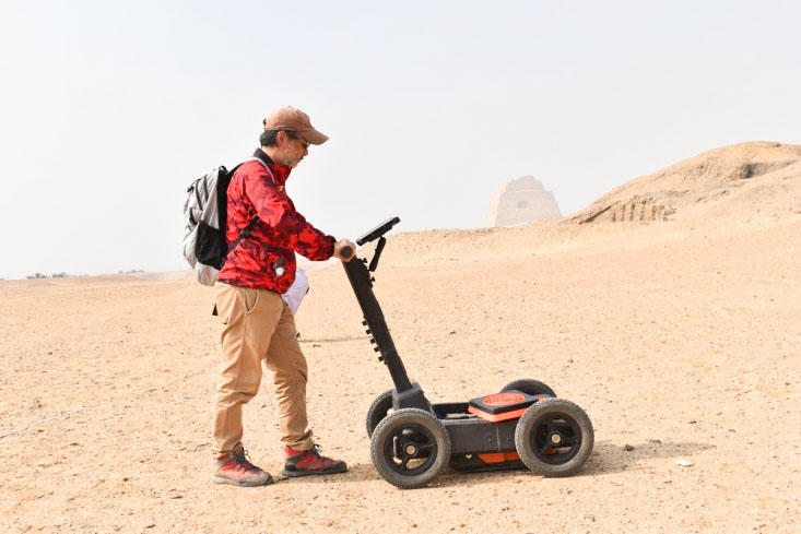 メイドゥム遺跡でKEYTEC株式会社の地下レーダーで探査中の大城先生(2019年7月)
